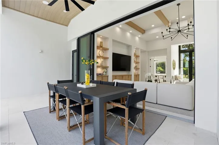 Dining area featuring built in shelves, beam ceiling, a chandelier, light tile patterned flooring, and recessed lighting