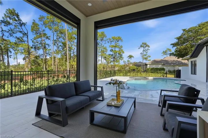 Fenced backyard featuring a patio, a pool with connected hot tub, and outdoor lounge area