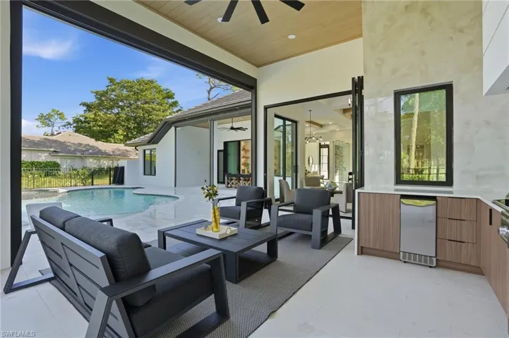 View of patio with a ceiling fan, outdoor lounge area, and a pool with connected hot tub
