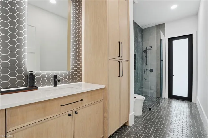 Full bath with vanity, a shower stall, recessed lighting, and dark tile patterned floors