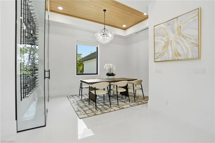 Dining room with wood ceiling, recessed lighting, a tray ceiling, and a chandelier