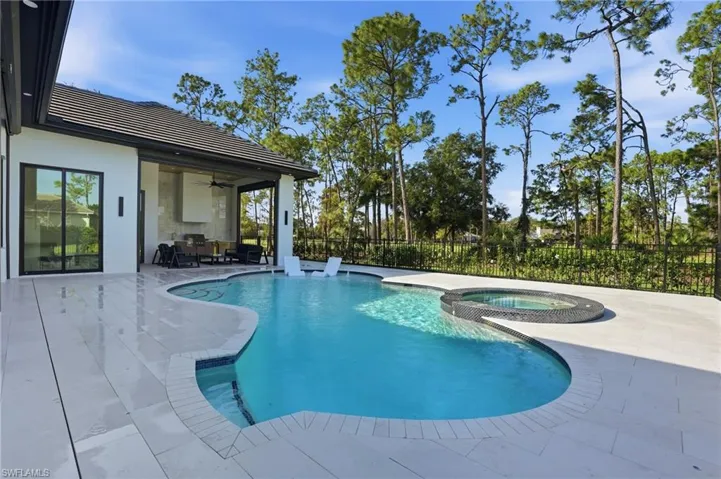View of pool featuring a patio and a pool with connected hot tub