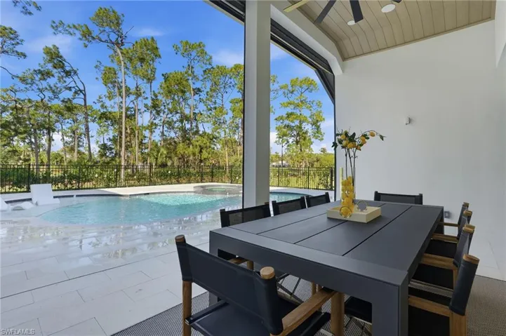View of swimming pool with a fenced backyard, a patio, outdoor dining area, and a pool with connected hot tub