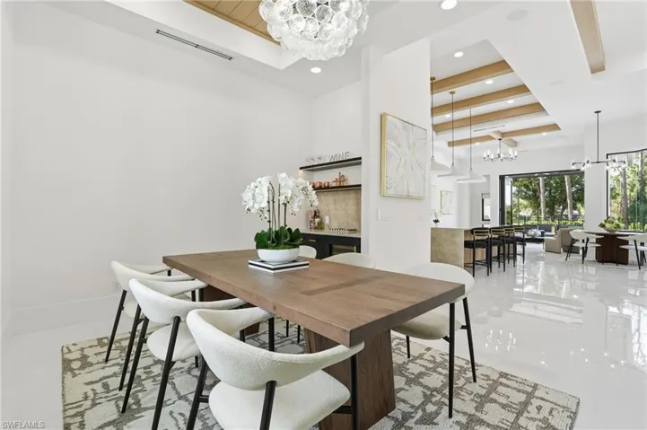 Dining area with a chandelier, beamed ceiling, recessed lighting, and coffered ceiling