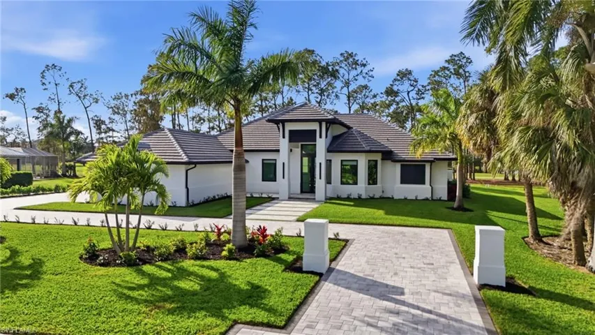Contemporary home with a front yard, stucco siding, and a tile roof