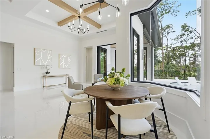 Dining area featuring coffered ceiling, a chandelier, beam ceiling, and recessed lighting