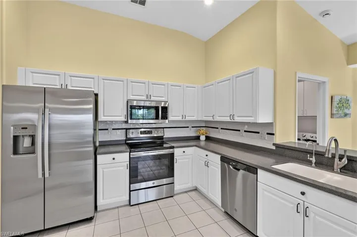 Kitchen with vaulted ceilings and beautiful backsplash.