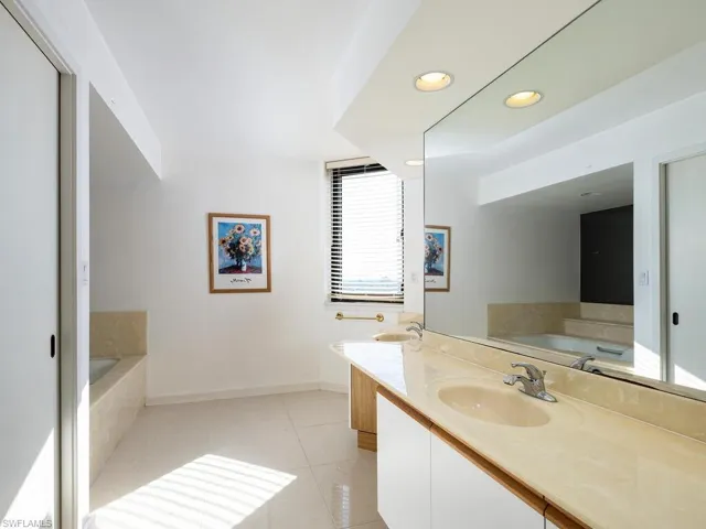 Bathroom featuring vanity, a bathing tub, and tile patterned flooring