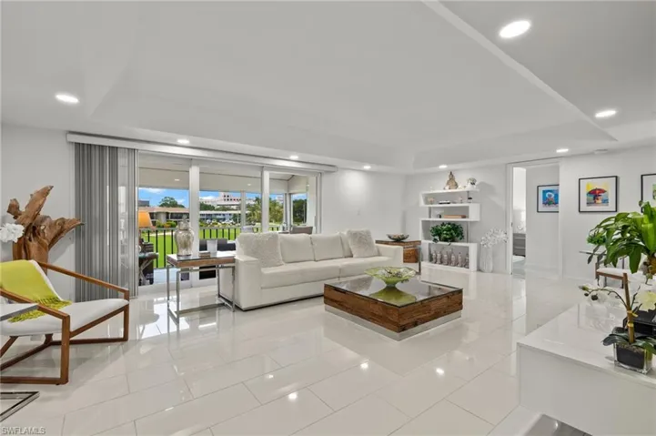 Living room featuring light tile patterned floors and a raised ceiling
