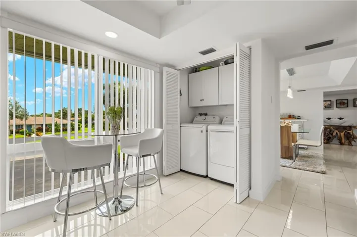 Washroom featuring independent washer and dryer, cabinets.