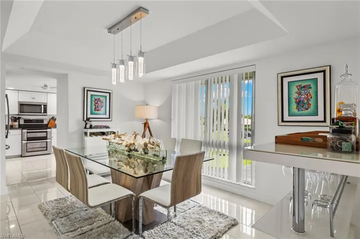 Tiled dining room featuring a tray ceiling
