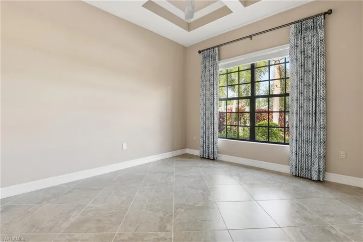 Empty room featuring coffered ceiling and baseboards