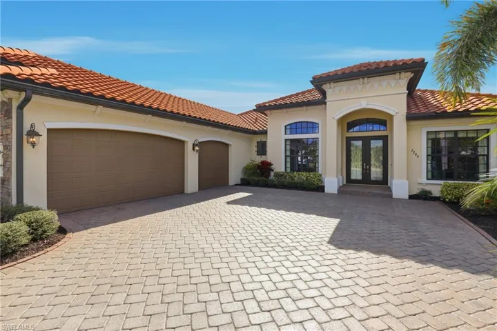Mediterranean / spanish house with decorative driveway, stucco siding, an attached garage, and a tiled roof