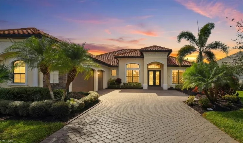 Mediterranean / spanish-style home featuring french doors, decorative driveway, an attached garage, a tiled roof, and stucco siding