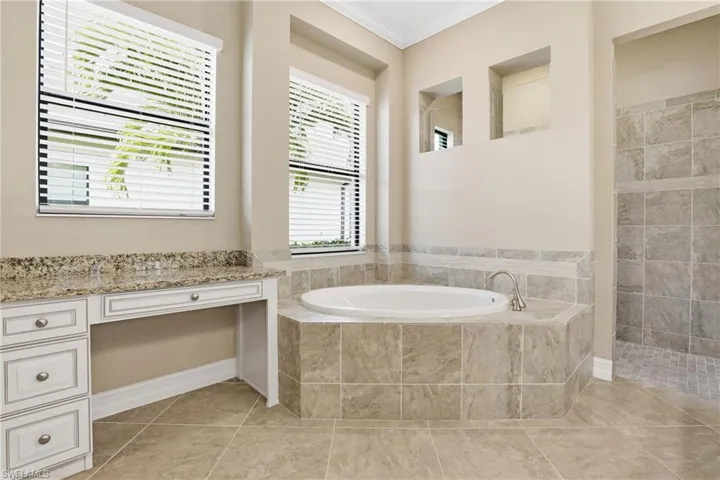 Full bathroom featuring a garden tub, ornamental molding, walk in shower, and light tile patterned floors
