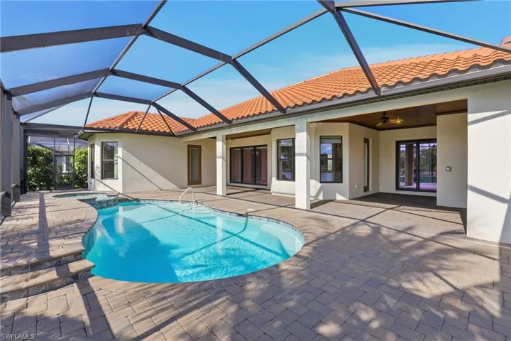 View of swimming pool featuring a sunroom, a patio area, a lanai, and a pool with connected hot tub