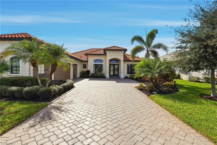 Mediterranean / spanish-style house with a tile roof, stucco siding, a garage, and decorative driveway
