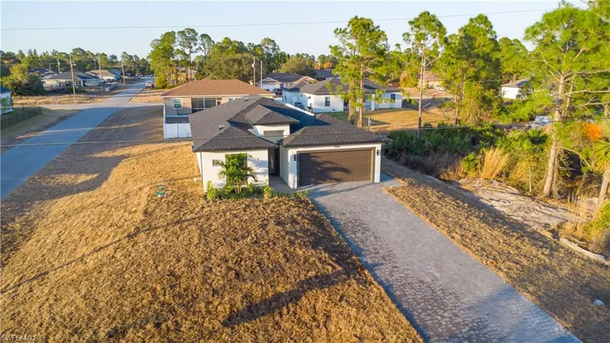 View of front facade with decorative driveway, a residential view, and an attached garage
