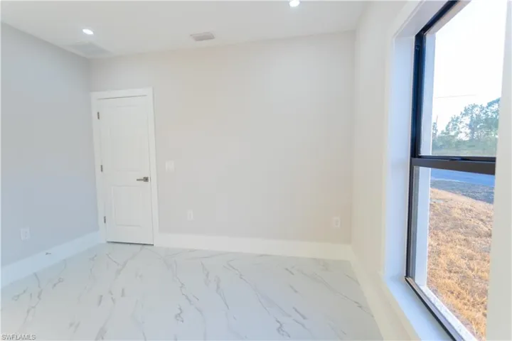 Spare room with marble look tile flooring and recessed lighting