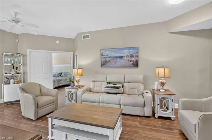 Vaulted ceiling, wood-finish flooring, recessed lighting, ceiling fan, and white doors to Primary bedroom