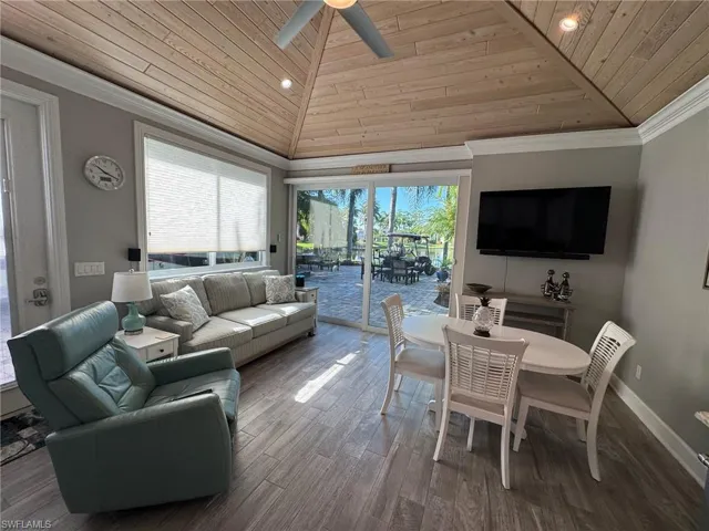 Living room with wooden ceiling, ornamental molding, hardwood / wood-style floors, high vaulted ceiling, and ceiling fan