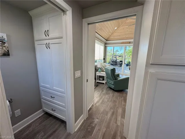 Hall featuring dark wood-type flooring and wooden ceiling