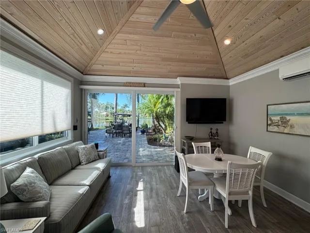 Living room with an AC wall unit, wooden ceiling, vaulted ceiling, and dark hardwood / wood-style floors