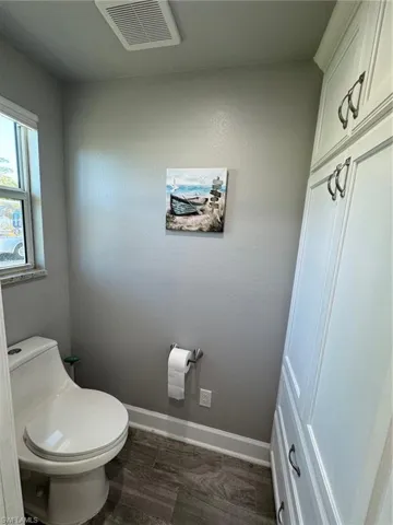 Bathroom with hardwood / wood-style flooring and toilet