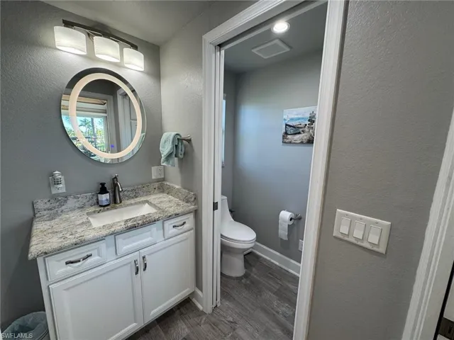Bathroom featuring toilet, hardwood / wood-style floors, and vanity