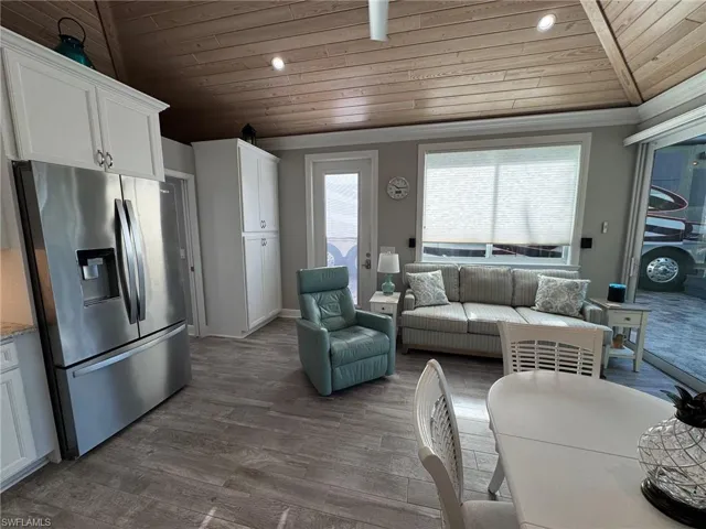 Living room with lofted ceiling, hardwood / wood-style floors, and wood ceiling
