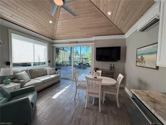 Dining room featuring wood ceiling, an AC wall unit, hardwood / wood-style floors, crown molding, and ceiling fan