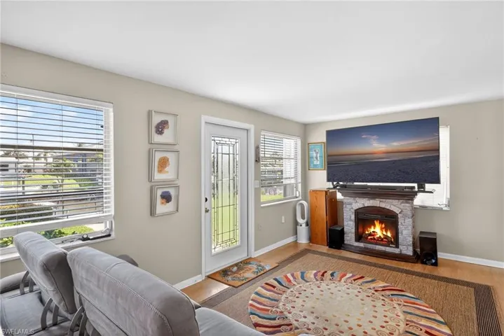 Living area with wood finished floors and a stone fireplace