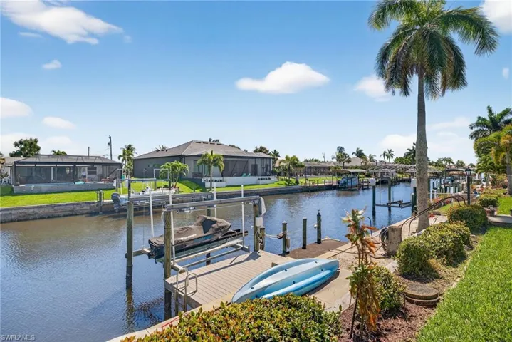 Dock area with boat lift, a water view, and a residential view