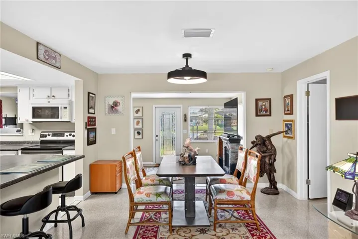 Dining area with dark speckled floor and baseboards