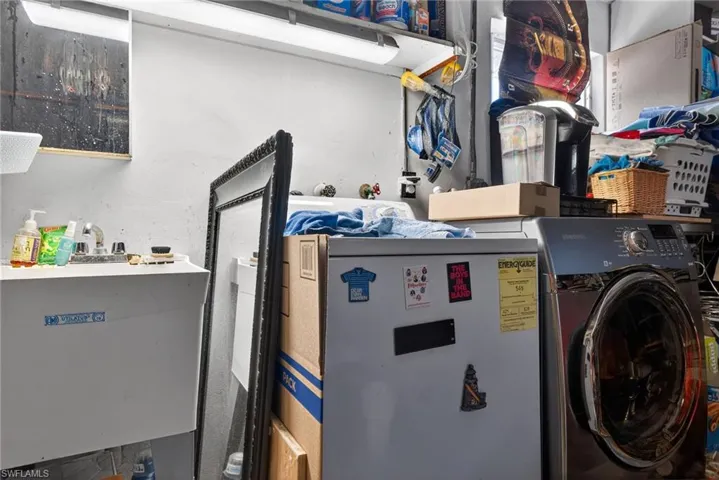Laundry area in garage featuring washer / dryer and a sink