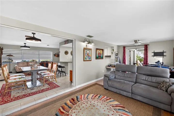 Living room featuring a ceiling fan, plenty of natural light, and light tile patterned floors