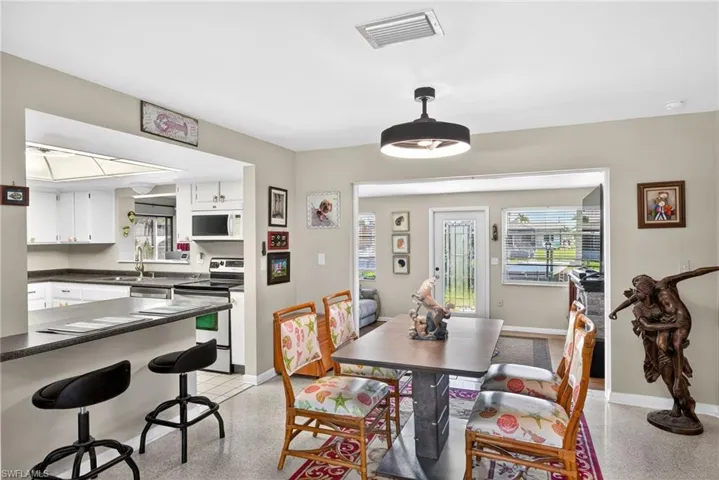 Dining space featuring dark aggregate flooring and baseboards