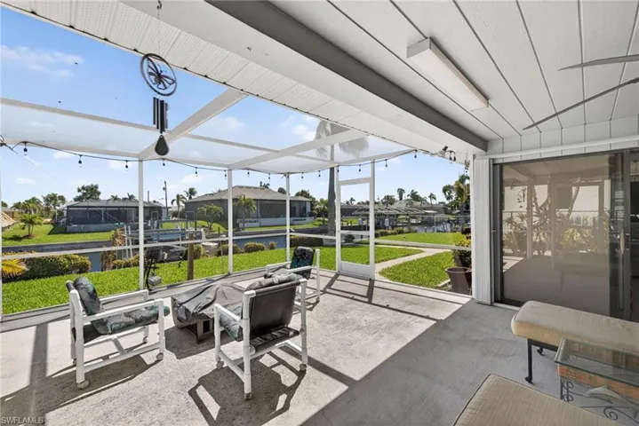 Sunroom / solarium featuring a patio area, an outdoor fire pit, a residential view, and a water view