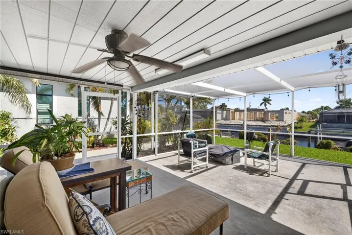 Sunroom with a ceiling fan, a patio, an outdoor hangout area, and a water view