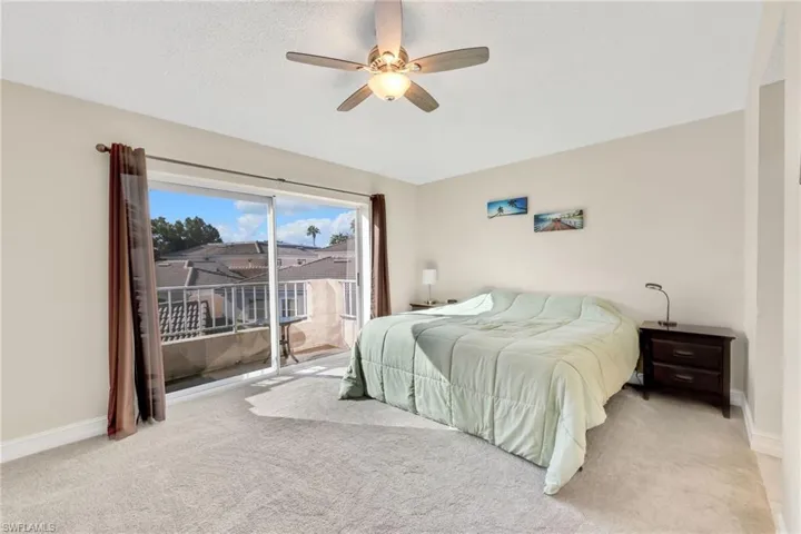 Primary Bedroom featuring access to exterior, carpet floors, ceiling fan. Balcony