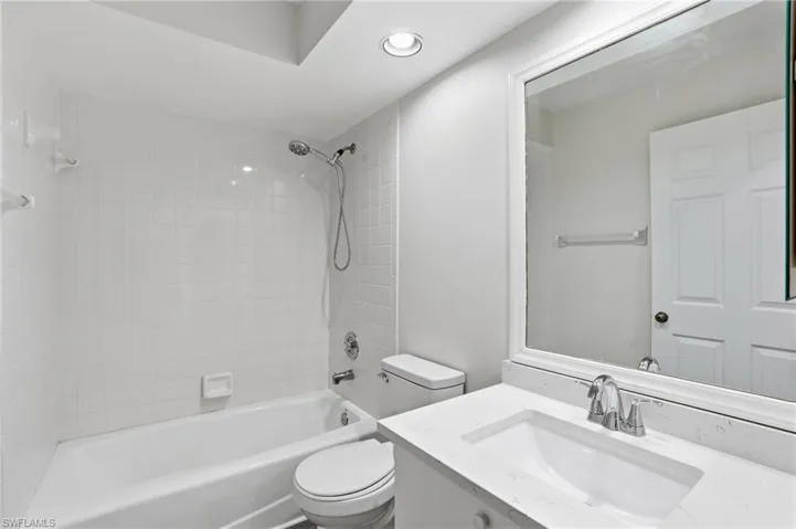 Shower with tub and sink with counter space.