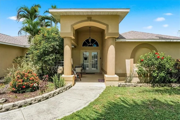 Stucco exterior with an arched portico entry and fluted columns