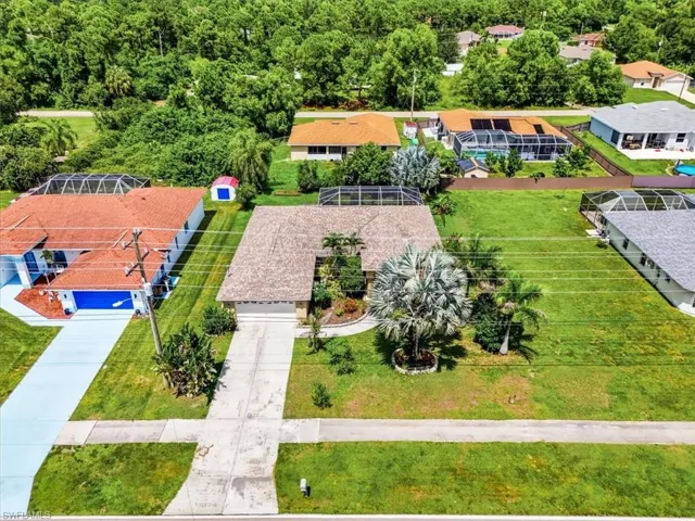 Single-story residence with an attached garage, concrete driveway, and mature landscaping