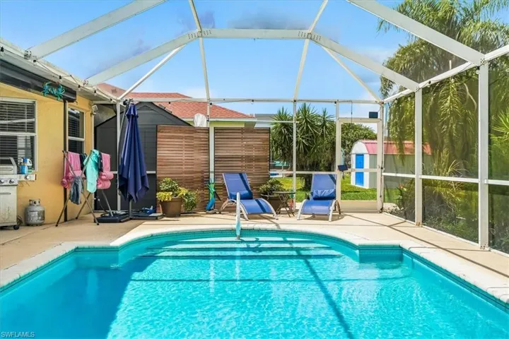 Screened outdoor swimming pool with concrete decking and integrated steps