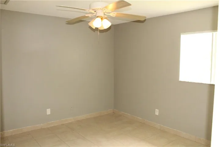 Empty room featuring baseboards and a ceiling fan