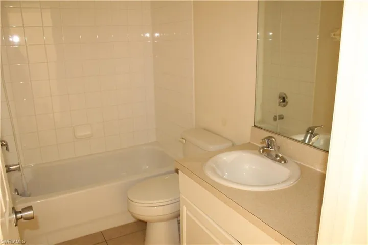 Bathroom featuring bathtub / shower combination, vanity, and tile patterned flooring