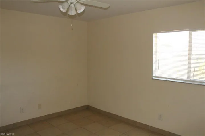 Spare room with a ceiling fan and light tile patterned floors
