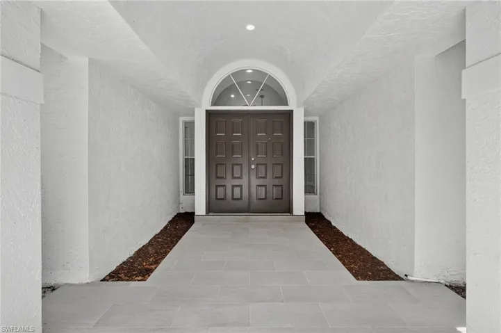 Entrance to property featuring stucco siding and tile entry