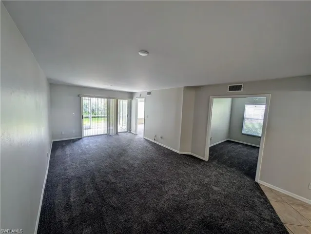 Empty room with healthy amount of natural light and light carpet