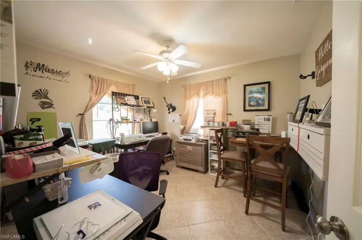 Office with light tile patterned floors and a ceiling fan